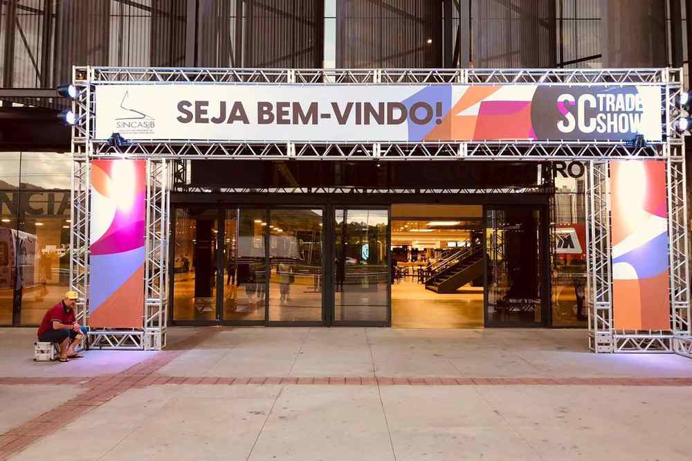 Portal de entrada de feira em treliça de alumínio com painéis impressos e iluminação